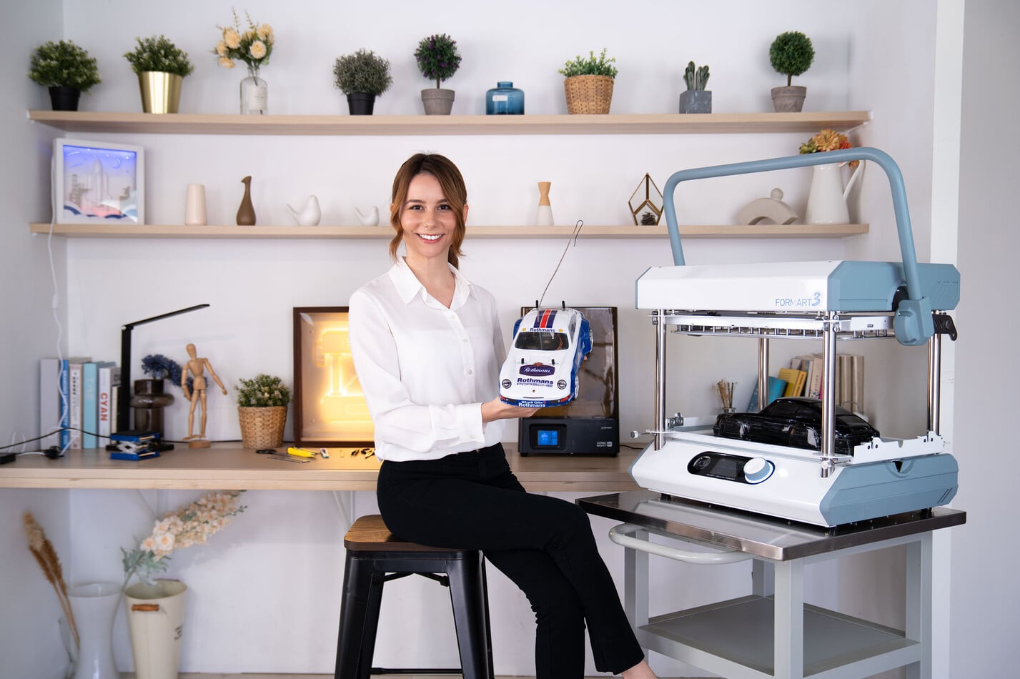 MY YARD FORMART 3 desktop vacuum former in use, with a woman holding a vacuum-formed RC car body